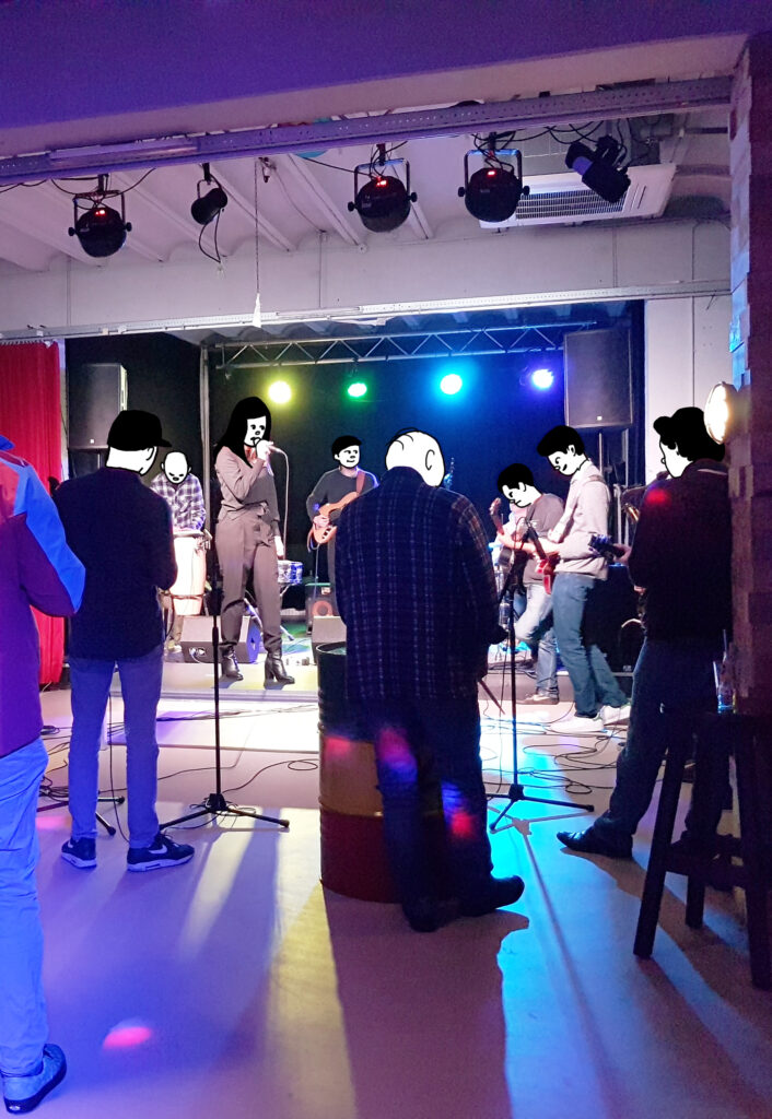 Photo of a stage with musicians and people surrounding them. 